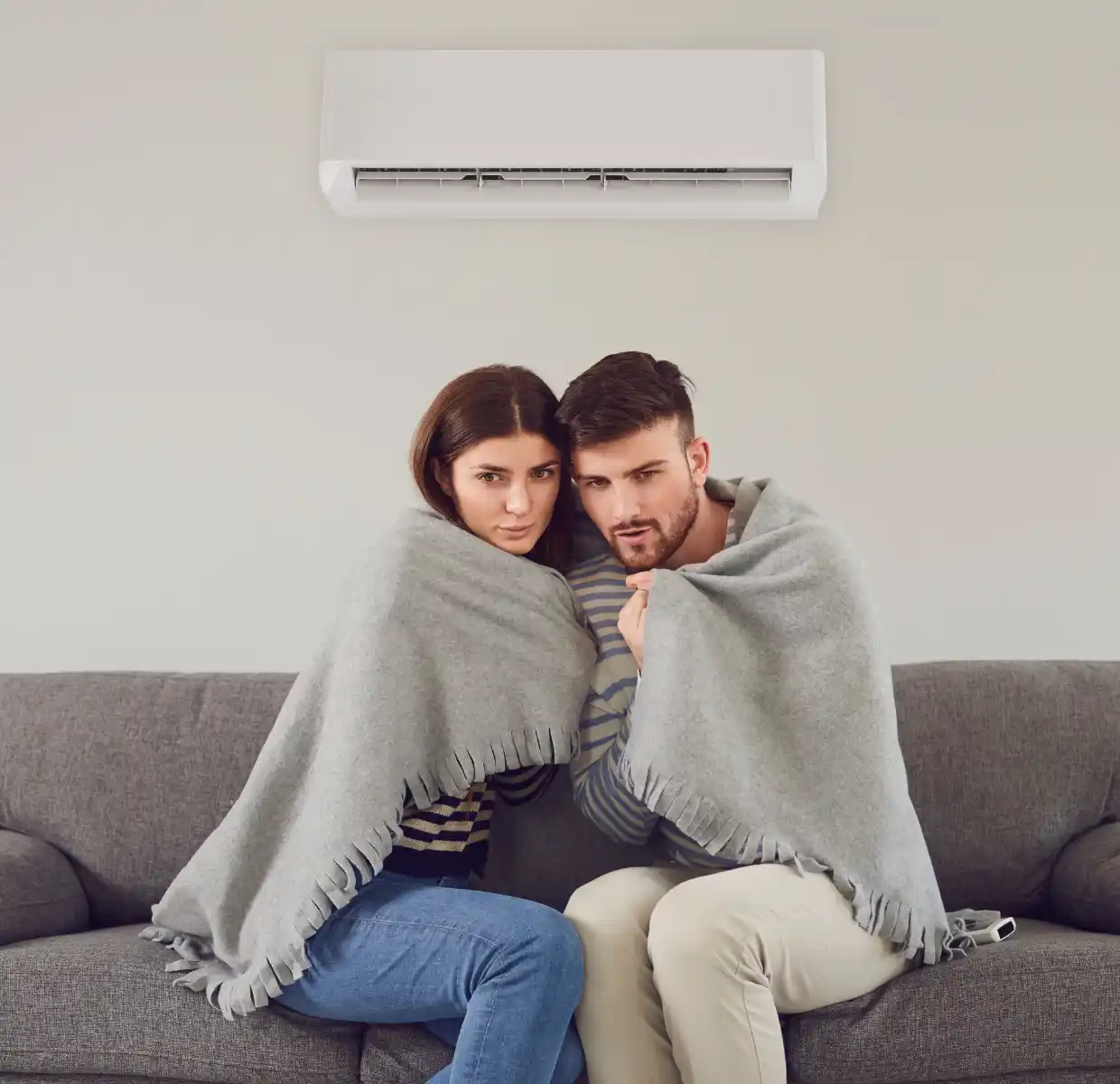 pareja con frio debajo del aire acondicionado
